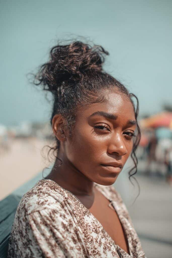 Black woman with knotless braided bun, wig updo hairstyle for Black women.
