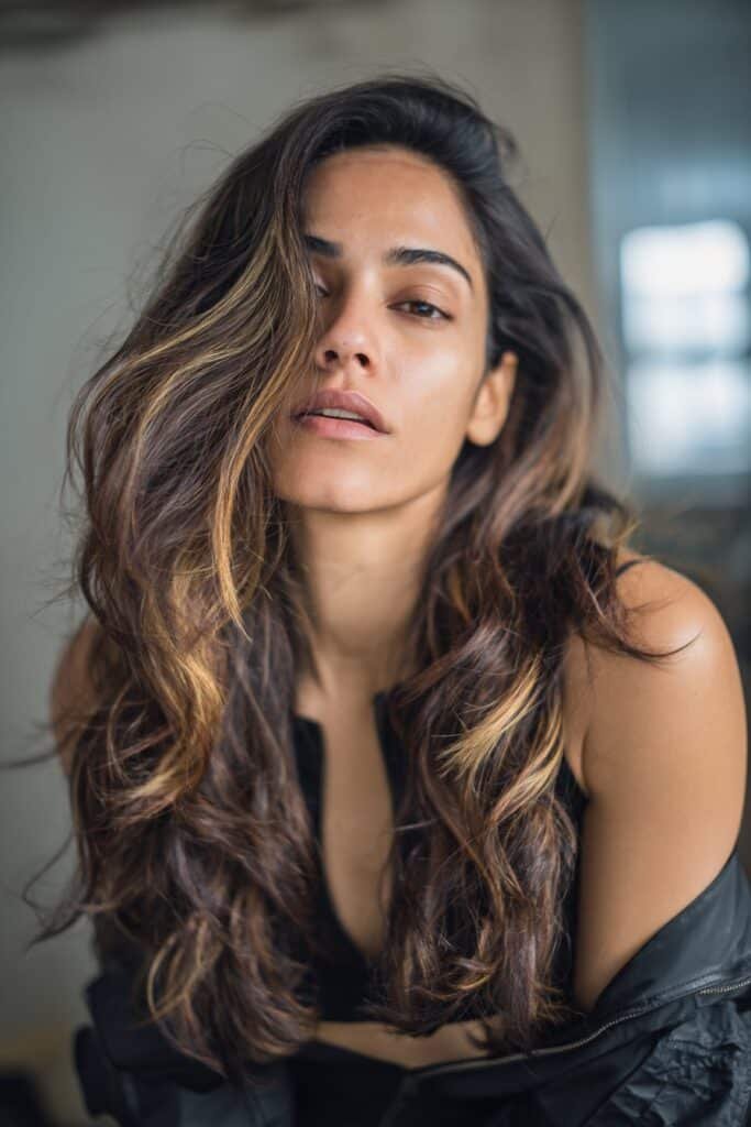 woman with dark brown hair and bold chunky highlights
