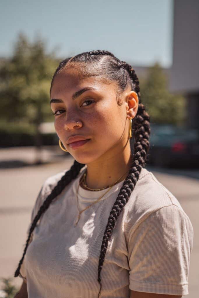 young woman with double cornrow ponytail, two braided ponytails, fun modern style