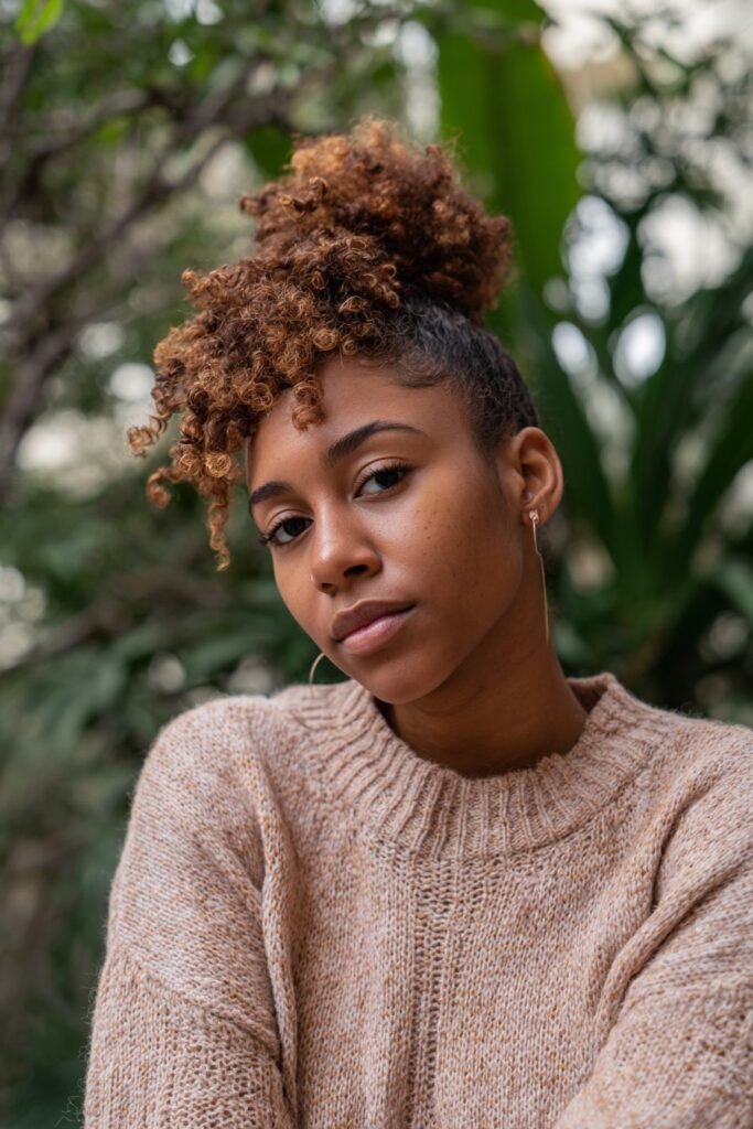 Black woman with half-up crown and natural coils.