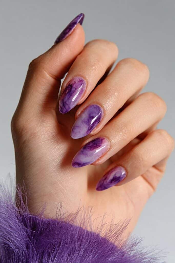 Purple smoke almond nails with flowing lavender and amethyst swirl patterns, full hand with fingers curved inward.