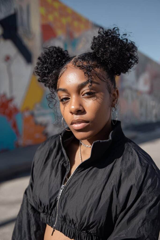 Black woman with playful space buns wig updo and neat edges.