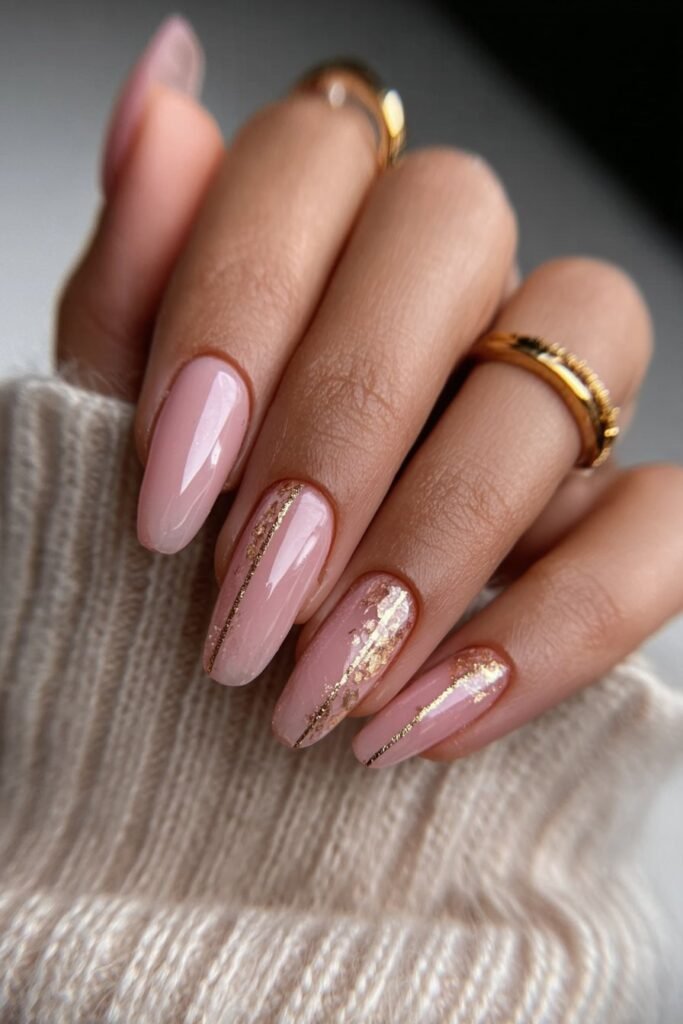 Soft pink nails with delicate gold foil and thin gold lines.