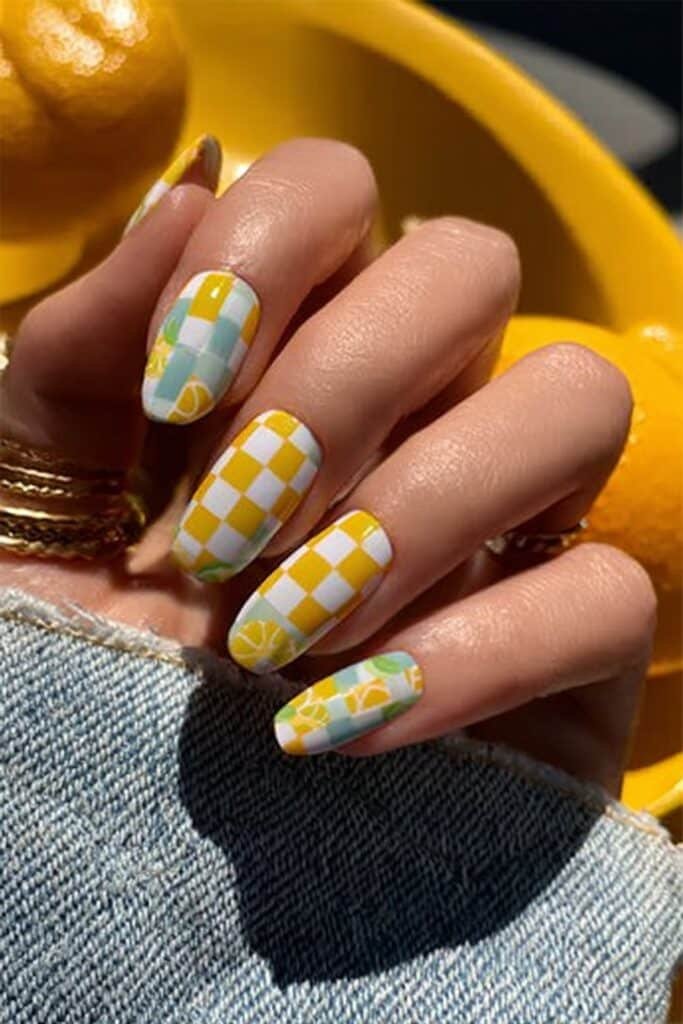 Retro checkerboard nails in lemon yellow and white with citrus accents.