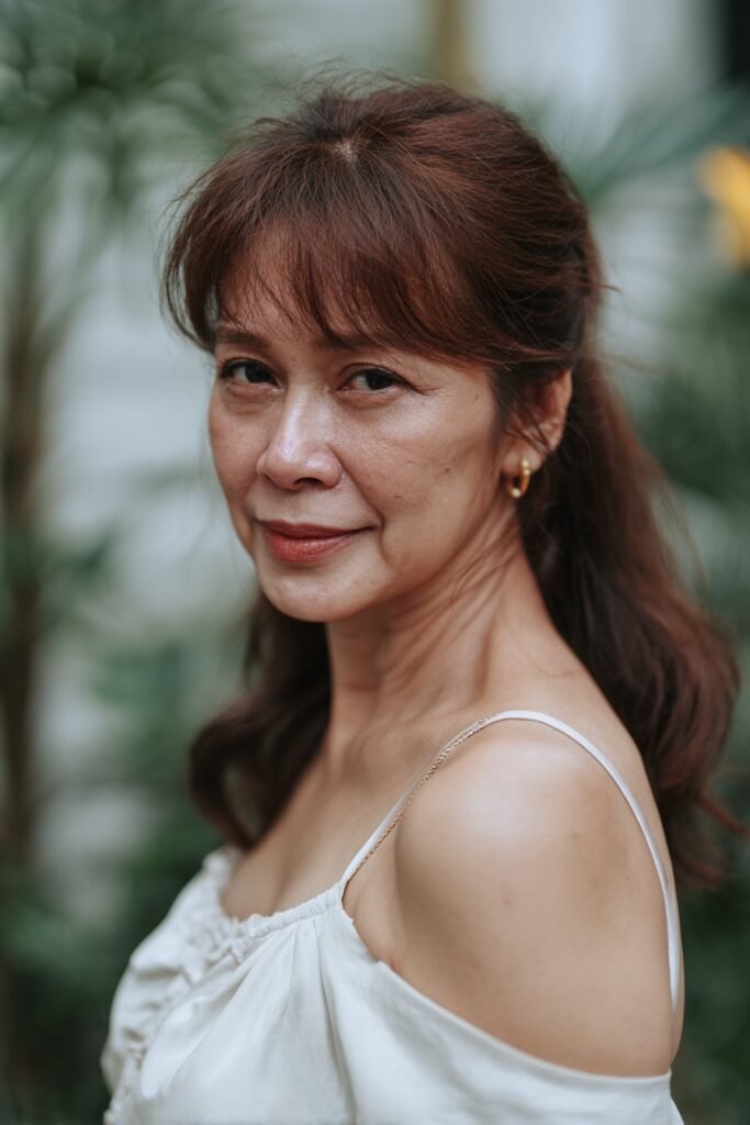 older woman with curtain bangs half up half down hairstyle