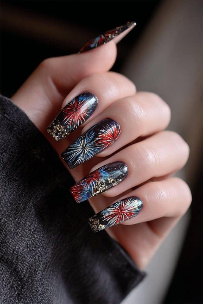 Dark nails with red, blue, and white fireworks spark designs.