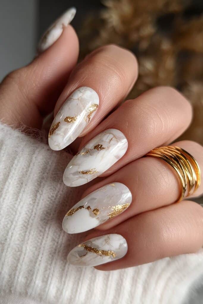 Marble nails with white swirls and delicate gold veins.