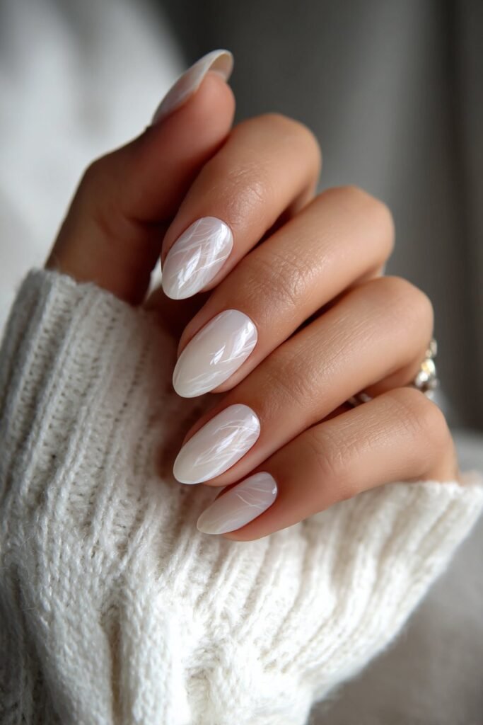 Milky white nails with soft swirl patterns and subtle marble effect.