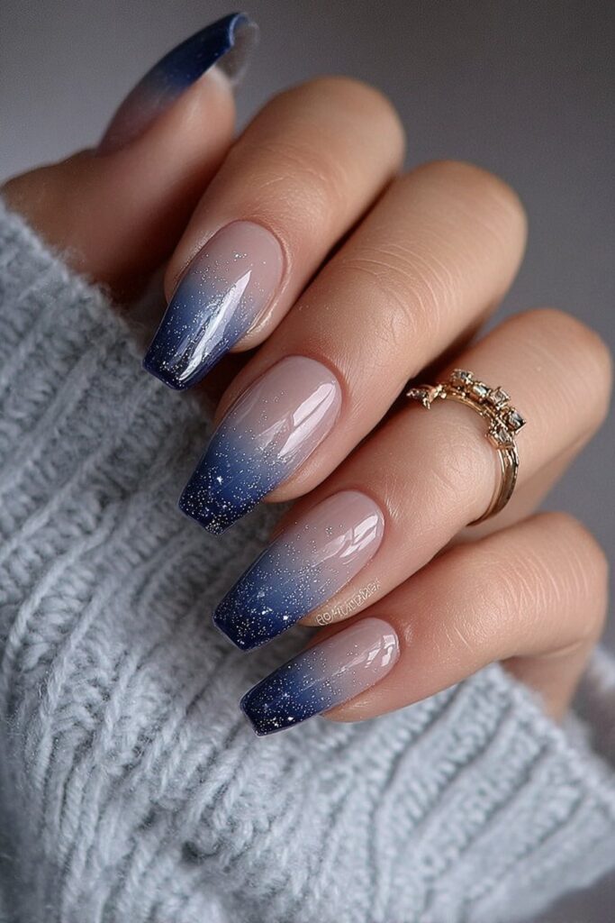 Navy blue ombre nails fading into soft white tips.