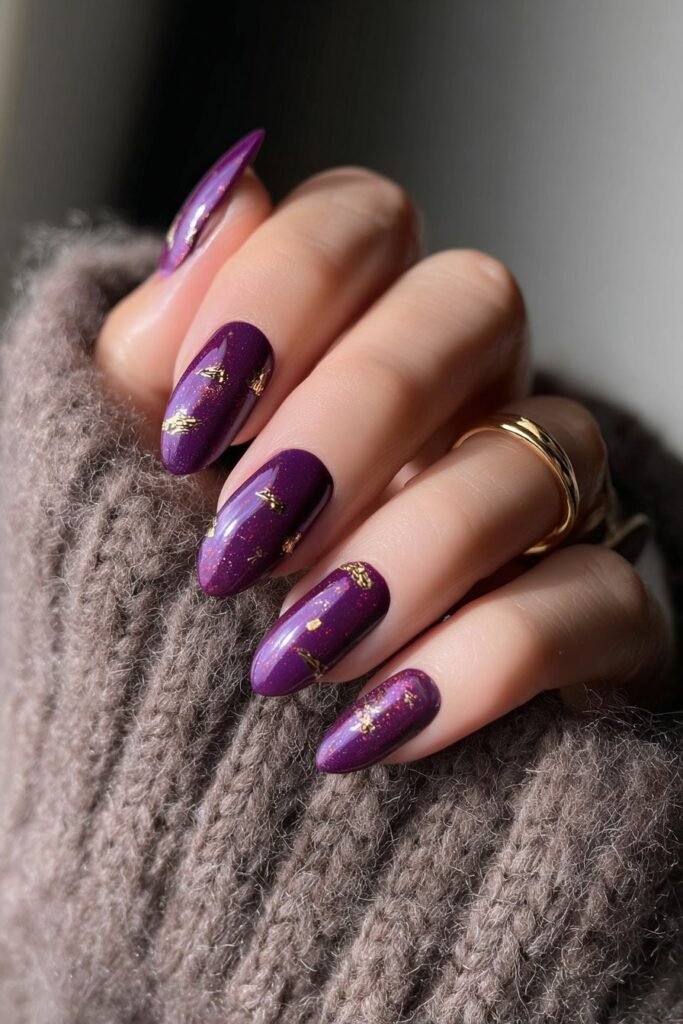 Purple nails with elegant gold accents and metallic details.