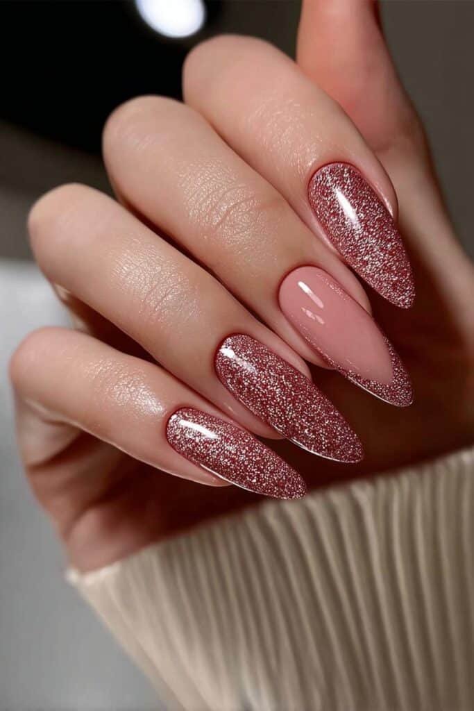 Almond nails covered in rose gold glitter with glossy shine.