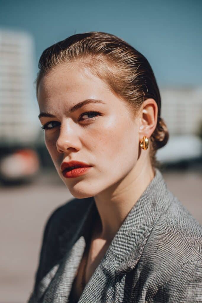 woman with slicked back hairstyle, smooth glossy finish