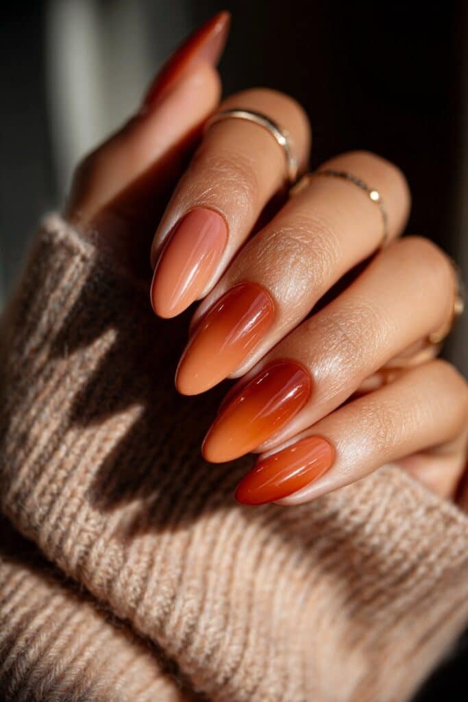 Ombre nails blending terracotta, peach, and golden tones.