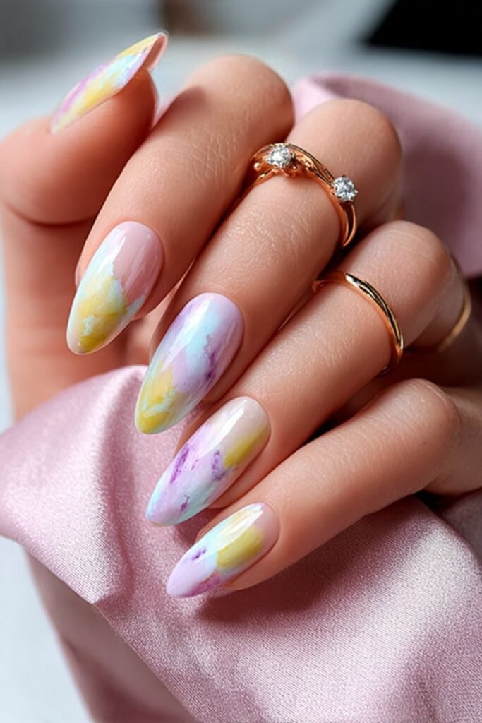 Watercolor nails blending lemon yellow, peach, and white tones.
