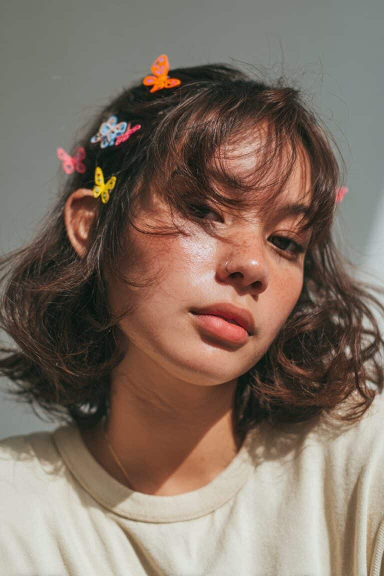 woman with pinned back bangs and colorful butterfly clips