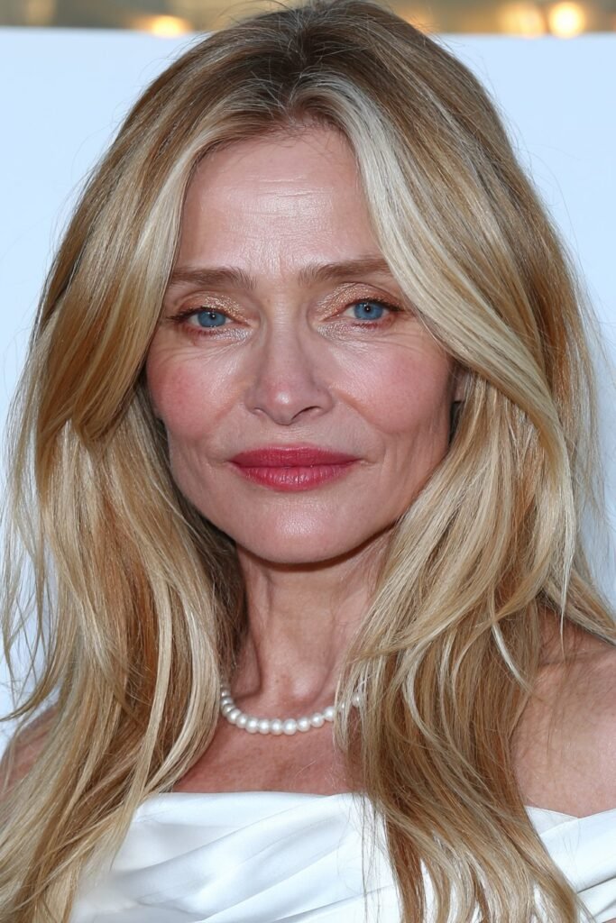 Older woman with curtain bangs and long flowing blonde layers.