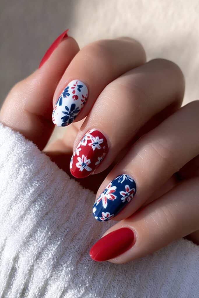 Patriotic floral nails in red, white, and blue tones.