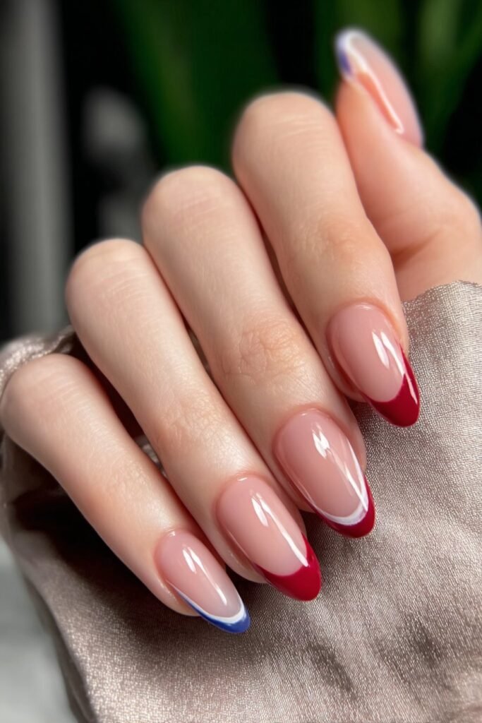 Modern French tip nails with red, white, and blue color blocking.