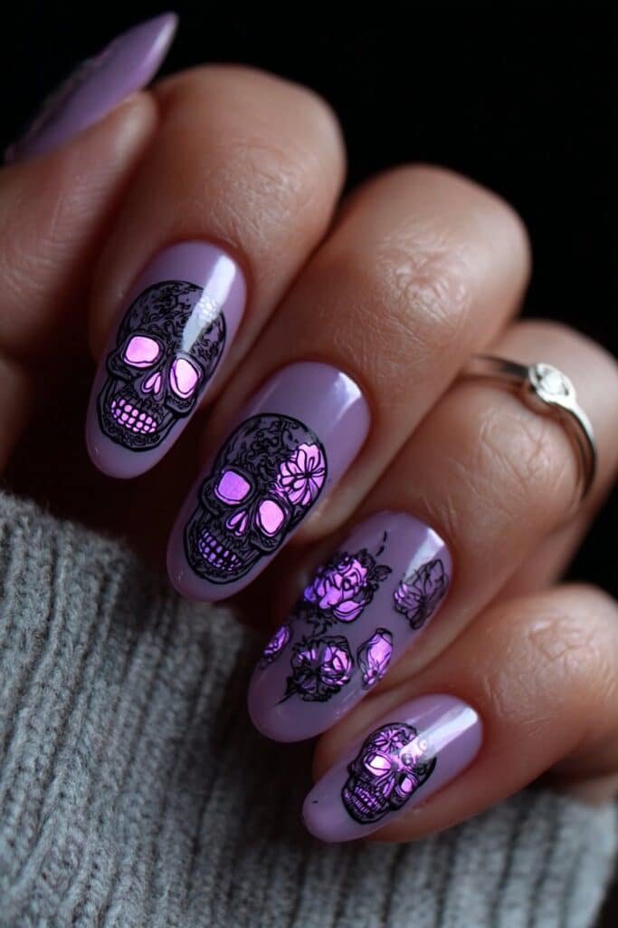 Lavender nails with tiny skulls and soft floral accents.