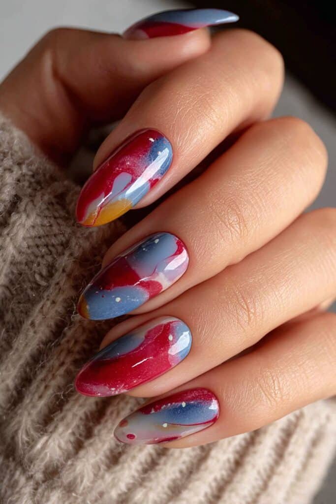 Red, white, and blue marble nails with elegant swirling patterns.