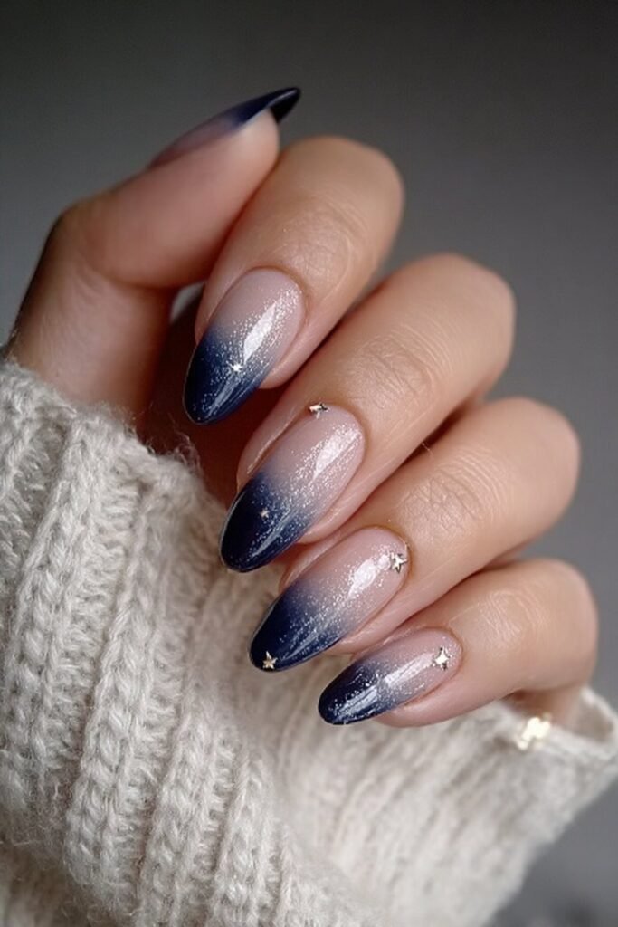 Navy blue ombre nails fading into soft white tips.