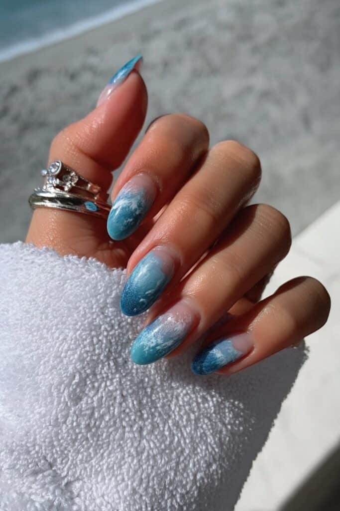 Ocean ombre nails blending aqua, turquoise, and white shades.