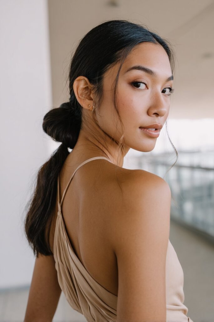 bridesmaid with sleek knotted half up hairstyle