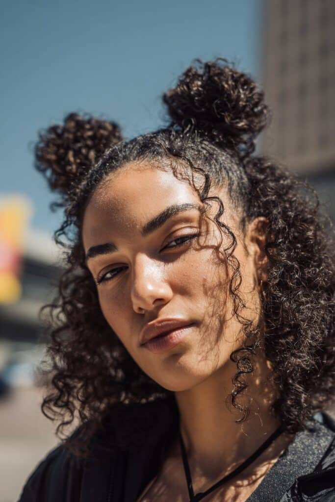 woman with curly space buns, playful natural curls