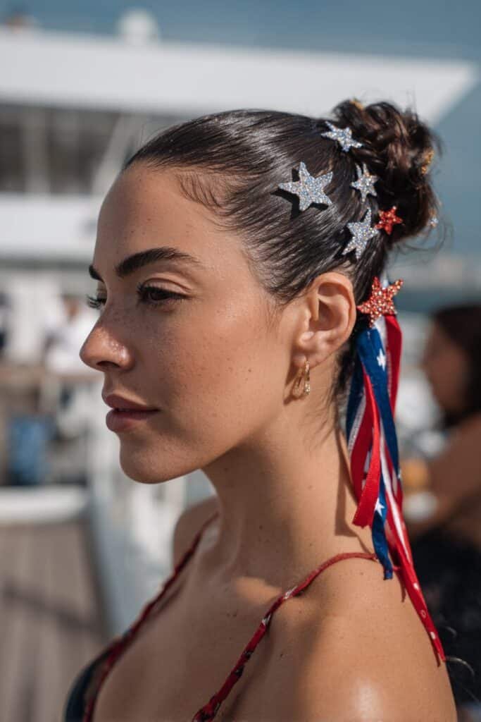 woman with sleek low bun and patriotic star pins