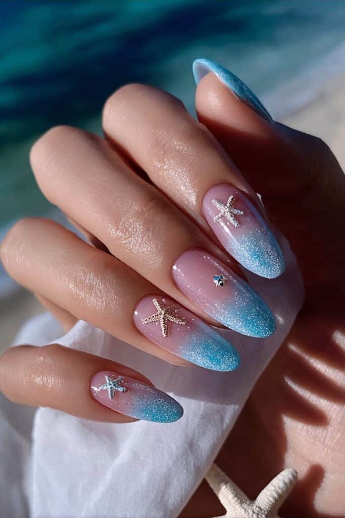 Beach inspired nails with tiny starfish and ocean blue details.