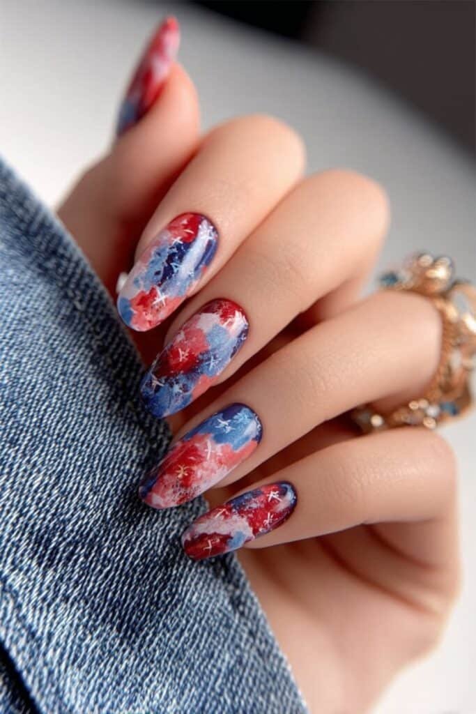 Watercolor patriotic nails in blended red, white, and blue shades.