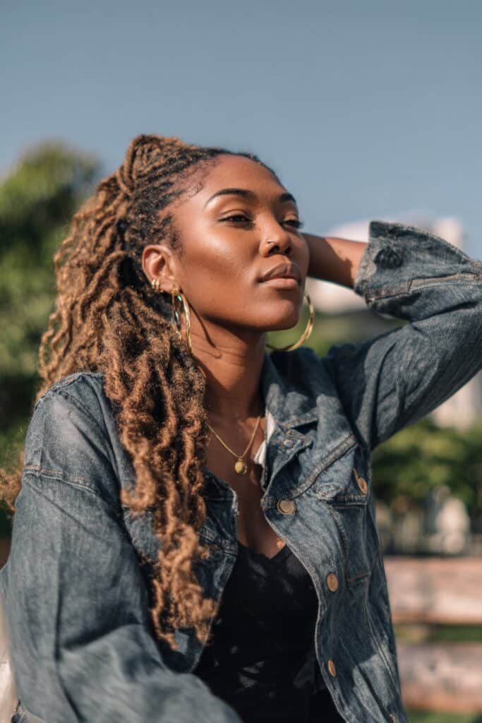 Black woman with a braid out hairstyle and fluffy kinky curls.