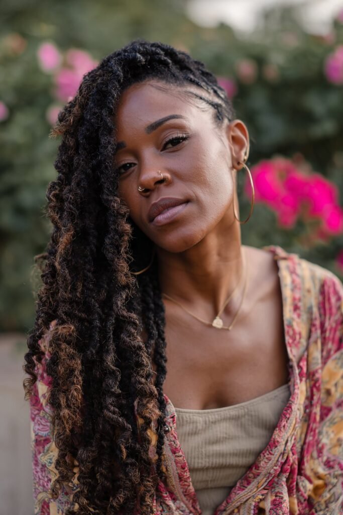 Black woman wearing goddess kinky twist braids with loose curls.