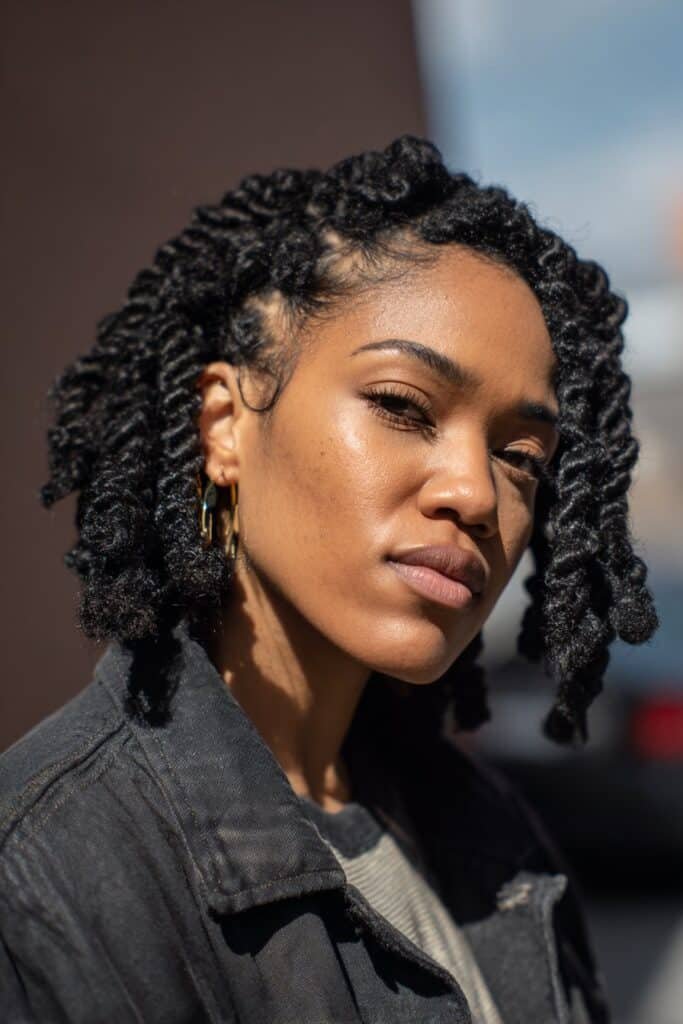 Black woman with jumbo kinky twists in a shoulder-length protective hairstyle.