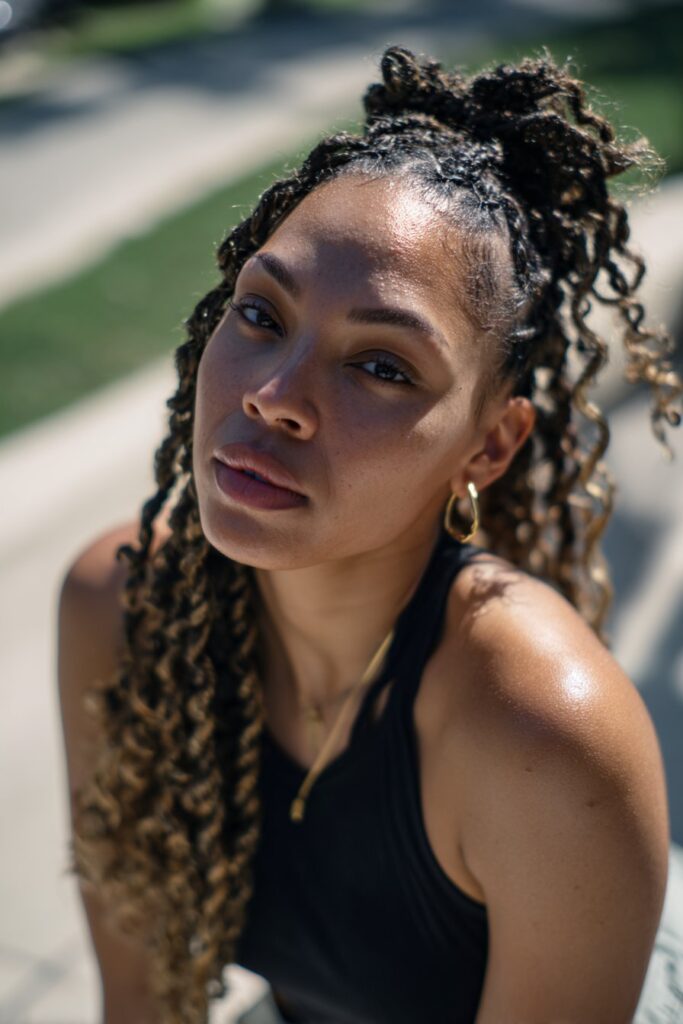 Black woman with half-up half-down kinky twist braids.