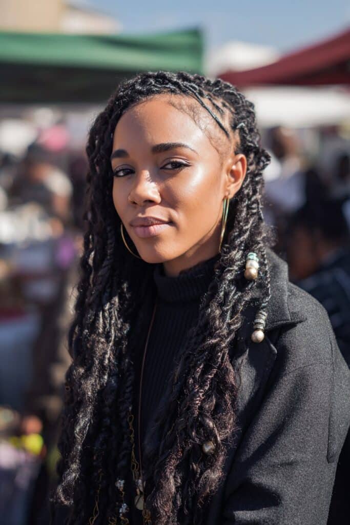 Black woman with kinky twist braids decorated with beads.