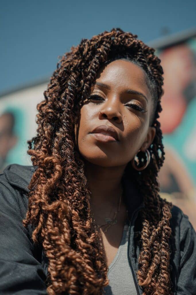 Black woman with kinky twist braids featuring copper color accents.