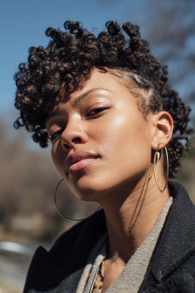 Black woman with starter locs formed from kinky curly natural hair.