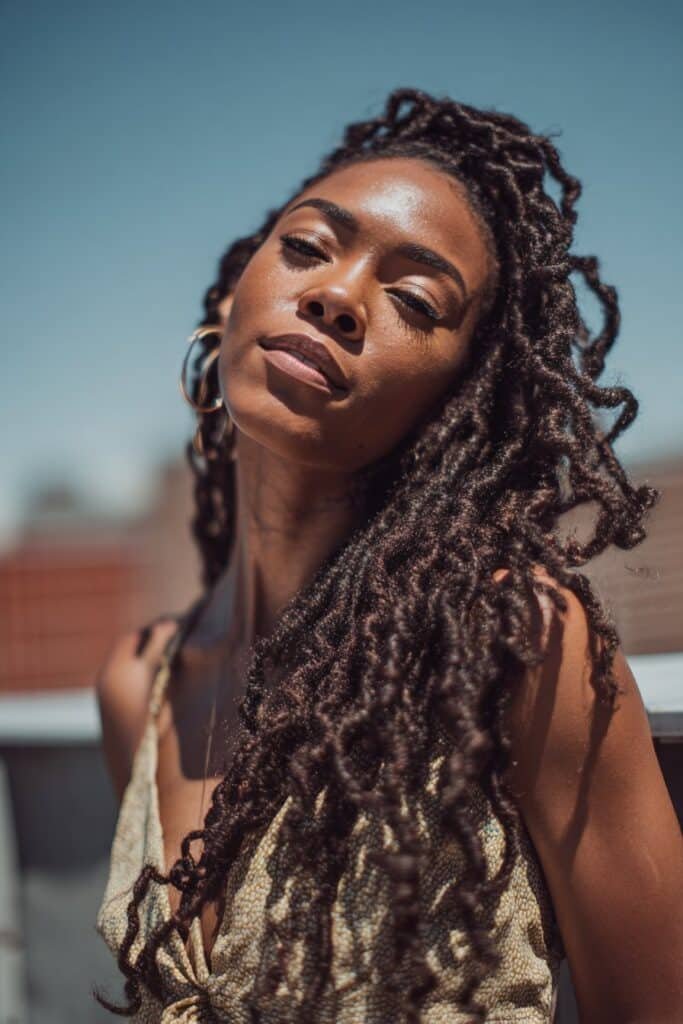 Black woman with long kinky twist braids flowing past her shoulders.