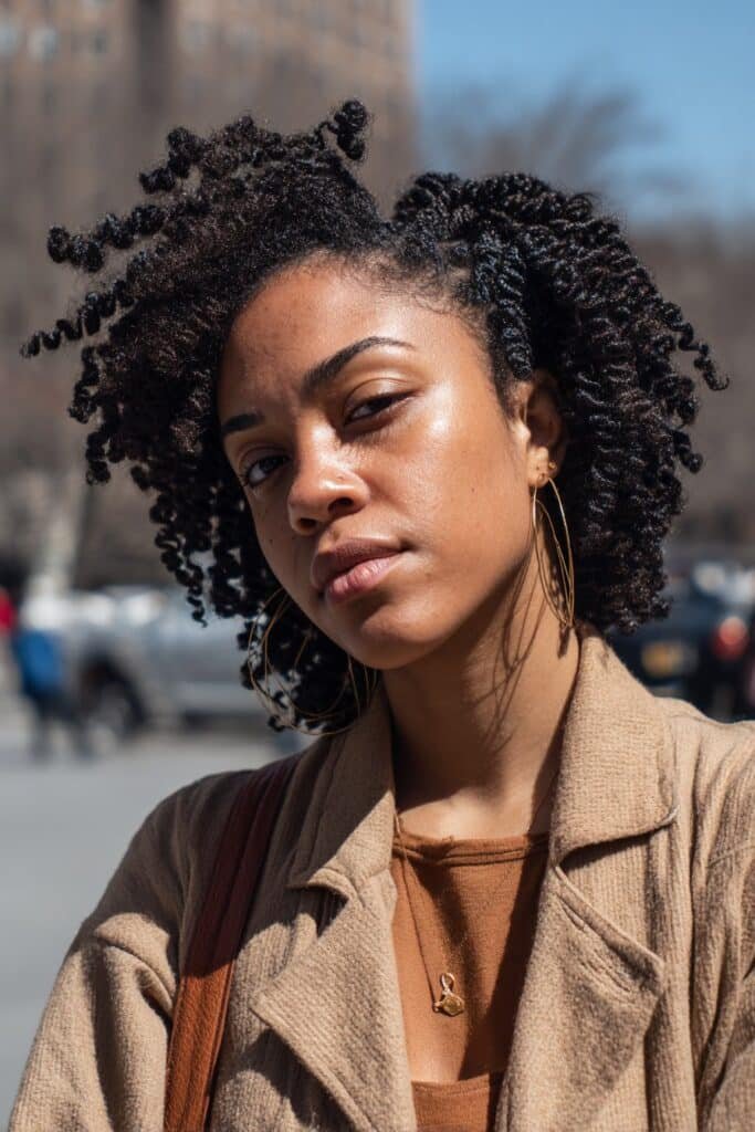 Black woman with medium kinky twists in a classic protective hairstyle.