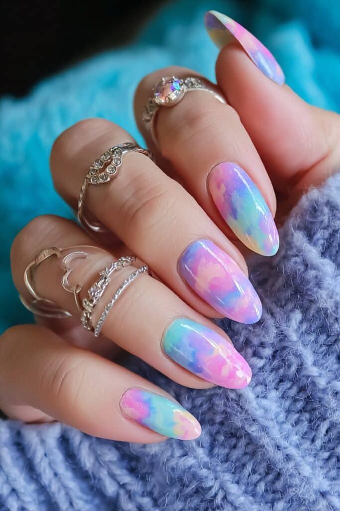 Pastel rainbow tie-dye nails with colorful swirl patterns.