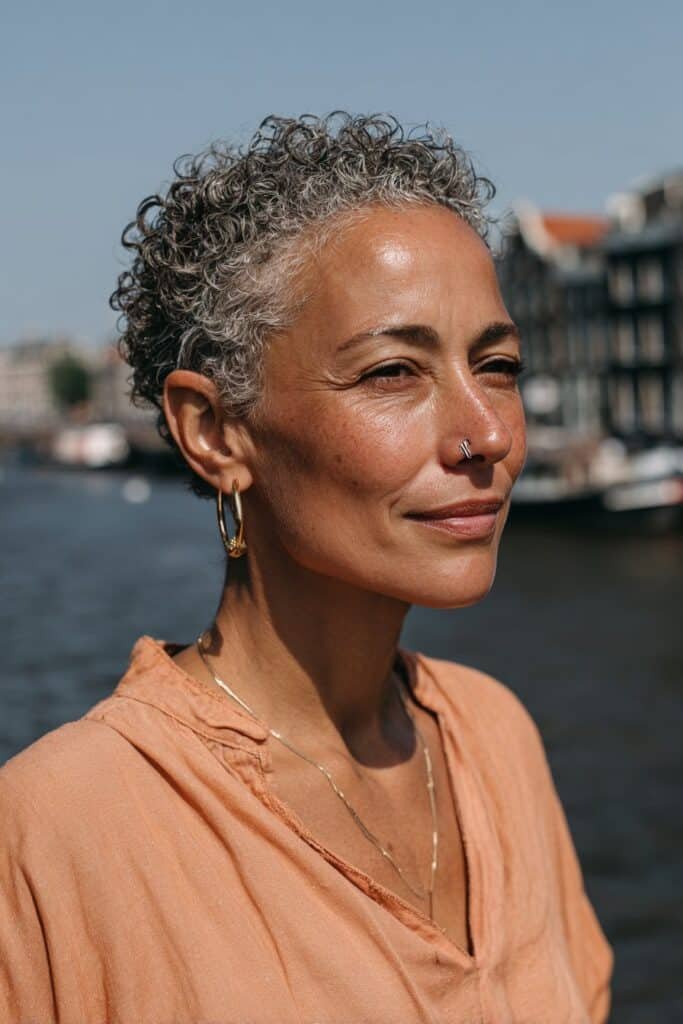Older woman with tapered curly crop hairstyle.