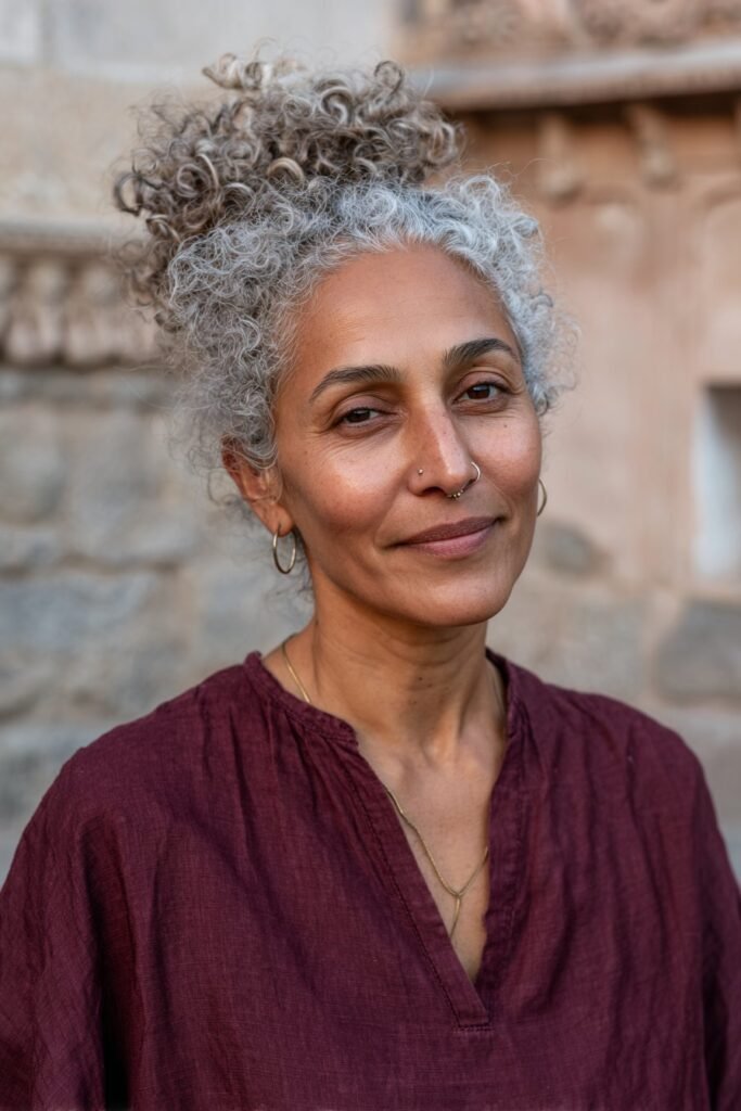 Older woman with voluminous curly updo hairstyle.