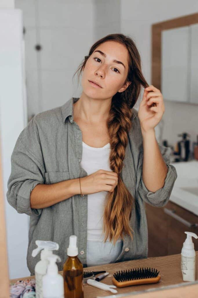 Preparing hair and gathering tools before starting a French braid tutorial.