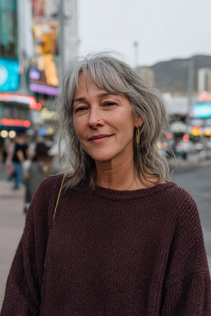 Smiling woman with a gray shag and soft eyebrow-skimming bangs