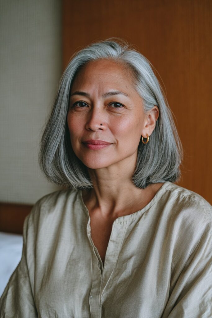 Older woman with a shoulder length cut and deep side part.