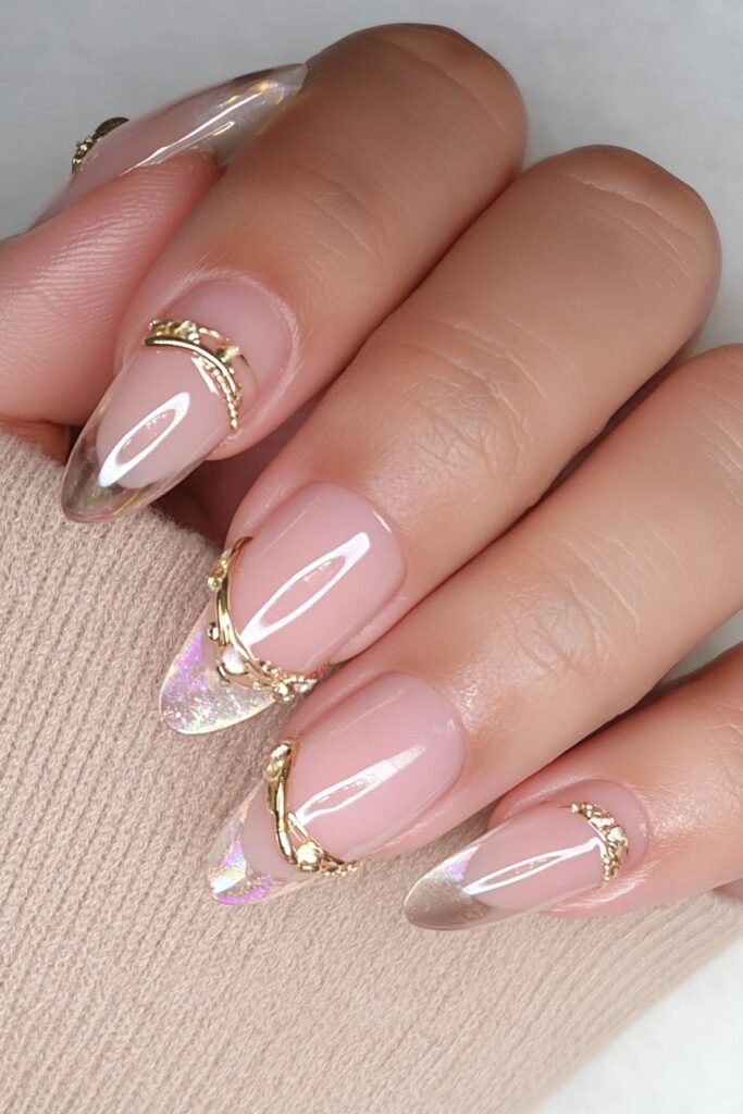 Sheer nude almond nails with raised 3D gold orbit accents.