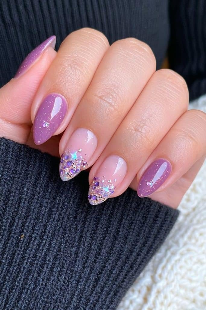 Short rich purple nails covered with delicate purple and silver rhinestones.