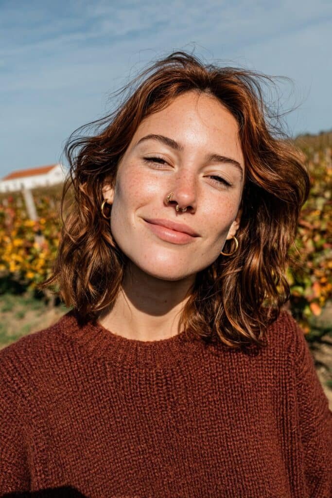 Brunette hair enhanced with warm auburn lowlights and glossy dimensional shine.