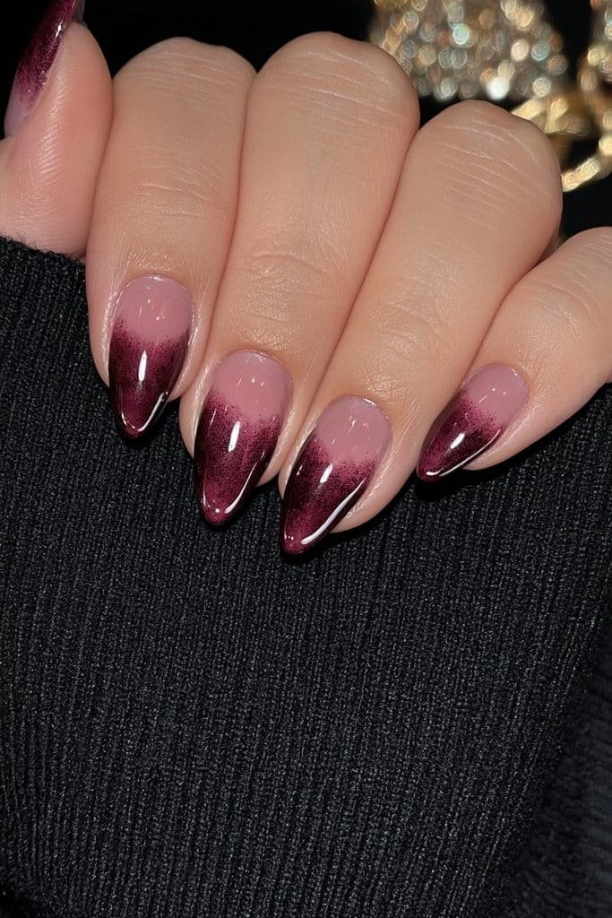 Short black-cherry burgundy almond nails with rich translucent glossy depth.